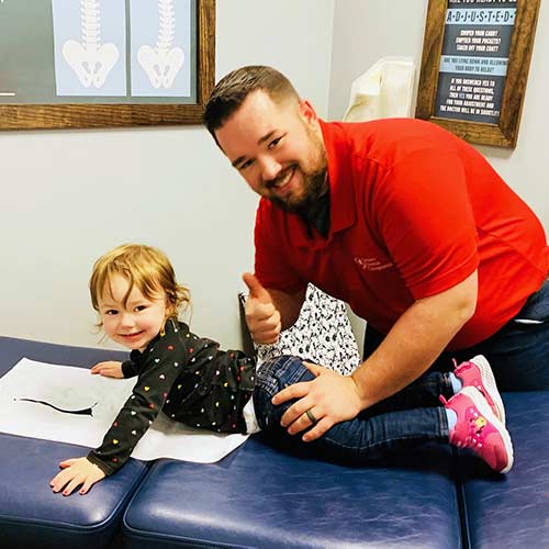Chiropractor Leland NC Dr. Marcus Woodburn and Child Patient