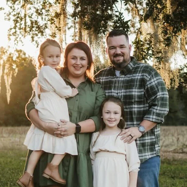 Chiropractor Marcus Woodburn with his family in front of a tree.