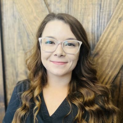 Pamela Creech, employee at Greatest Potential Chiropractic, headshot in front of a wooden wall